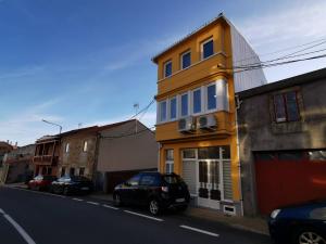 un edificio amarillo al costado de una calle en Apartamento Alfareiro, en Malpica de Bergantiños