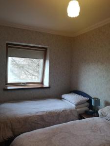 a bedroom with two beds and a window at Granville Guest House in Dyce