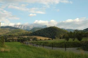 a fence in a field with mountains in the background at Torre del mig in La Seu d'Urgell