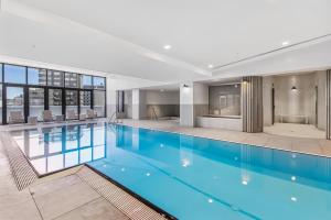 a large swimming pool with blue water in a building at Atop the Melbourne CBD with Panoramic Views DUPLICATE in Melbourne