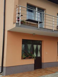 a building with a balcony and a door with flowers at STUDIO APARTMAN MARIA in Čavle