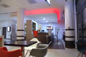a restaurant with a table and chairs and a bar at Ibis Dakar in Dakar