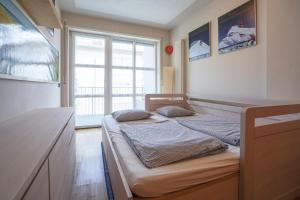 a bedroom with a bed and a large window at Hike & Bike Home Helena in Arco