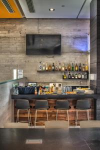 a bar in a restaurant with chairs and a television at Casa Inn Galerias Celaya in Celaya