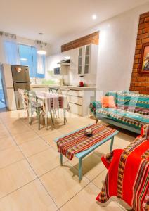 a living room with a table and a kitchen at Apartment Acogedor in Huanchaco