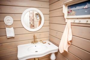 uma casa de banho com um lavatório e um espelho em Pastoral Resort em Velikiy Les