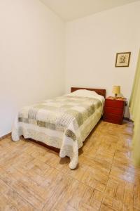 1 dormitorio con 1 cama y suelo de madera en Apartment Acogedor, en Huanchaco