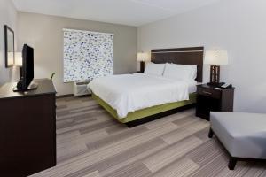 a hotel room with a bed and a flat screen tv at Holiday Inn Express Hotel & Suites Montgomery Boyd-Cooper Parkway by IHG in Montgomery +32 photos