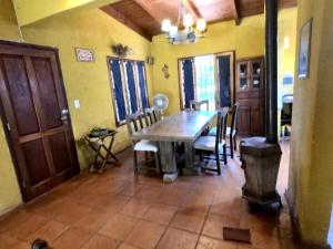 a dining room with a wooden table and chairs at Casa de Veraneo en Villa La Bolsa in Villa Anizacate