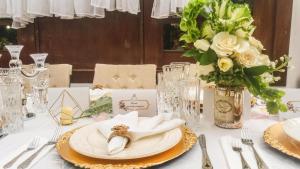 una mesa con un plato y un jarrón con flores en Casa Lolita Hotel-Boutique, en Portoviejo