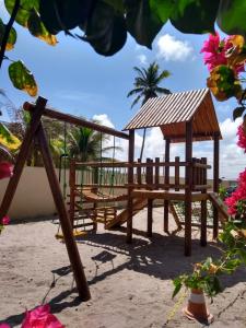 ポルト・デ・ガリーニャスにあるFlat Manawa A03のビーチにガゼボのある木製の遊び場