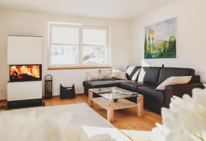 a living room with a couch and a fireplace at Haus Harmony Apartments in Ramsau am Dachstein