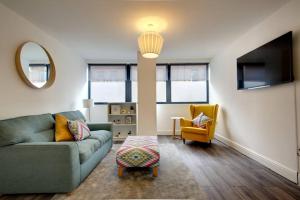 a living room with a green couch and a yellow chair at Stylish Sheffield City Spot in Sheffield