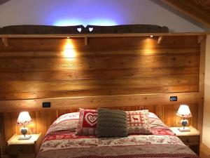 a bedroom with a wooden wall with a bed at Au Coin Du Chateau in Châtillon