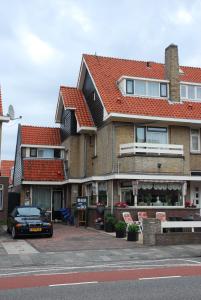 a house with a car parked in front of it at Bed And No Breakfast Joy in Noordwijk aan Zee