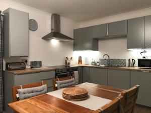 uma cozinha com uma mesa de madeira e uma sala de jantar em CROFT 14 SWORDALE em Swordale