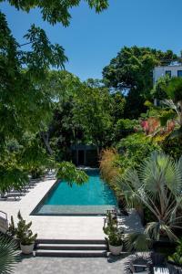 a swimming pool in a garden with trees at Villa Paranaguá Hotel & Spa - Boutique Hotel in Rio de Janeiro