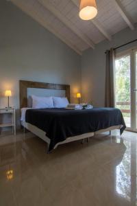 um quarto com uma cama grande e uma janela grande em Villa Elaia Suites & Apartments No.6 em Gaios