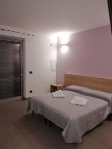 een slaapkamer met 2 bedden en handdoeken bij B&B Italia in Carmiano