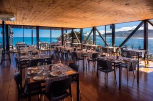 um restaurante com mesas e cadeiras e vista para o oceano em Hotel Puerto Viejo Llico em Llico