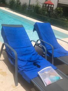 two blue beach chairs next to a swimming pool at Studio Torre Rio - IMPECABLE STUDIO, LUMINOSO, CHIC - EXCELENTE UBICACIÓN - PALERMO in Buenos Aires