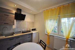 a kitchen with a table and a sink and a window at Waldi Apartament Cieplice in Jelenia Góra