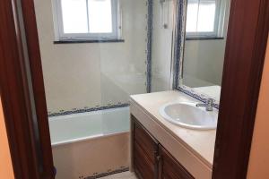 a bathroom with a sink and a mirror and a tub at Golf, Beach & Pool House in Amoreira +16 photos