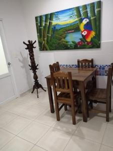 a dining room with a table and chairs and a painting at Finca Hotel Villa Ilusión in Pereira