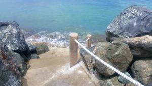 圣胡安CozyBeach large 1BdrApt 50 steps from Atlantic Ocean private street between Ocean Park & Isla Verde 5 mins from Airport的通往水面的阶梯,岩石