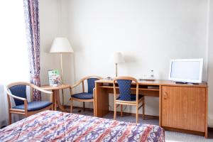 a hotel room with a desk with chairs and a computer at Hotel Szydłowski in Gdańsk