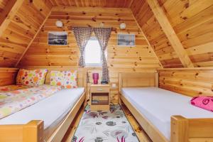 a bedroom with two beds in a log cabin at Cottage Borje in Žabljak