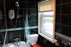 baño con aseo y lavabo y ventana en Loch Arklet House, en Stirling