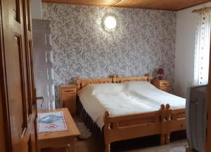 Un dormitorio con una cama y una mesa con televisión. en Pensiunea Laura, en Bran 8 fotos más