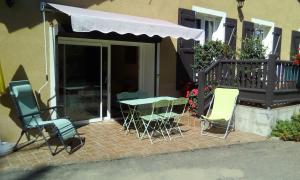 a patio with chairs and a table with an awning at Appartement a la campagne in Poyanne