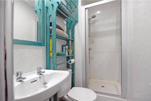 a bathroom with a sink and a toilet and a shower at Unique, perfectly located town centre house in Lerwick