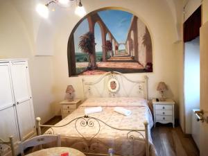 Schlafzimmer mit einem Bett mit Wandgemälde in der Unterkunft Archetto Bianco in Martina Franca