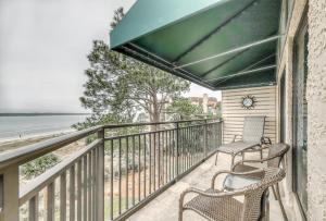 d'un balcon avec deux chaises et une vue sur la plage. dans l'établissement Beachside Tennis Condos, à Île de Hilton-Head