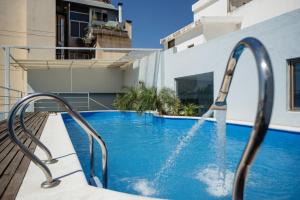 una piscina con una fuente de agua en Santiago Hotel en Córdoba