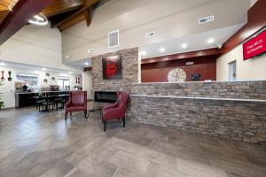 a restaurant with red chairs and a stone bar at Red Roof Inn Lumberton in Lumberton