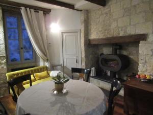 a dining room with a table and a stove at Les 5 terrasses et sa piscine privée in La Sauvetat