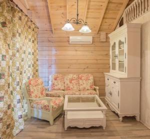 ein Wohnzimmer mit 2 Stühlen und einem Schrank in der Unterkunft Pastoral Resort in Velikiy Les