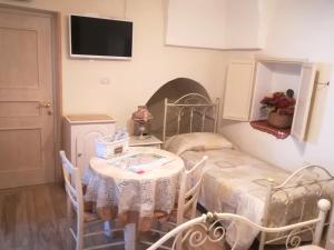 a small room with a table and a bed and a tv at Archetto Bianco in Martina Franca