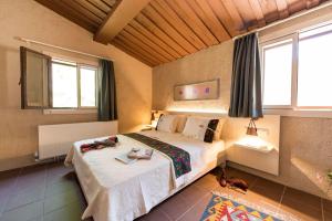 a bedroom with a bed in a room with windows at MANEJ URLA in Izmir