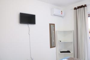 a room with a tv on a white wall at Hospedagem Penha - Beto carreiro e Praias in Penha