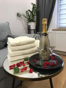 a bottle of champagne and two glasses on a table at Apartament Przy Promenadzie in Jelenia Góra