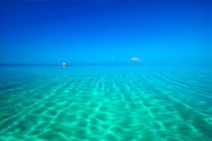 a view of the ocean with a boat in the distance at Kissos Apartments in Vourvourou