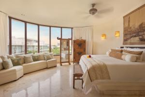 - une chambre avec un grand lit et un canapé dans l'établissement Porto Playa Condo Hotel and Beach Club, à Playa del Carmen