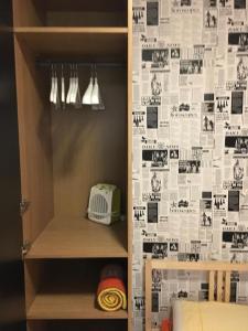 a cupboard with a wall with photos on it at Practical room: Barcelona-Fira-Airport in Hospitalet de Llobregat