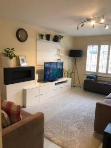 a living room with a flat screen tv sitting on a cabinet at Deptfort House - 7 Minutes to London Bridge Station in London