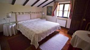 um quarto com uma cama grande e uma janela em Casa Rural Ozollo em Gautegiz Arteaga